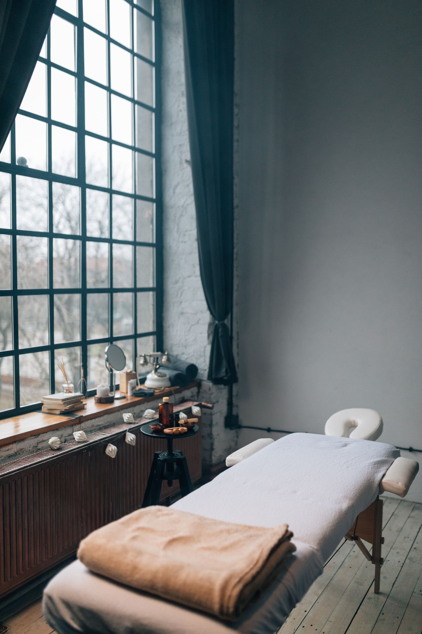 Ruhiger Behandlungsraum mit Liege am Fenster